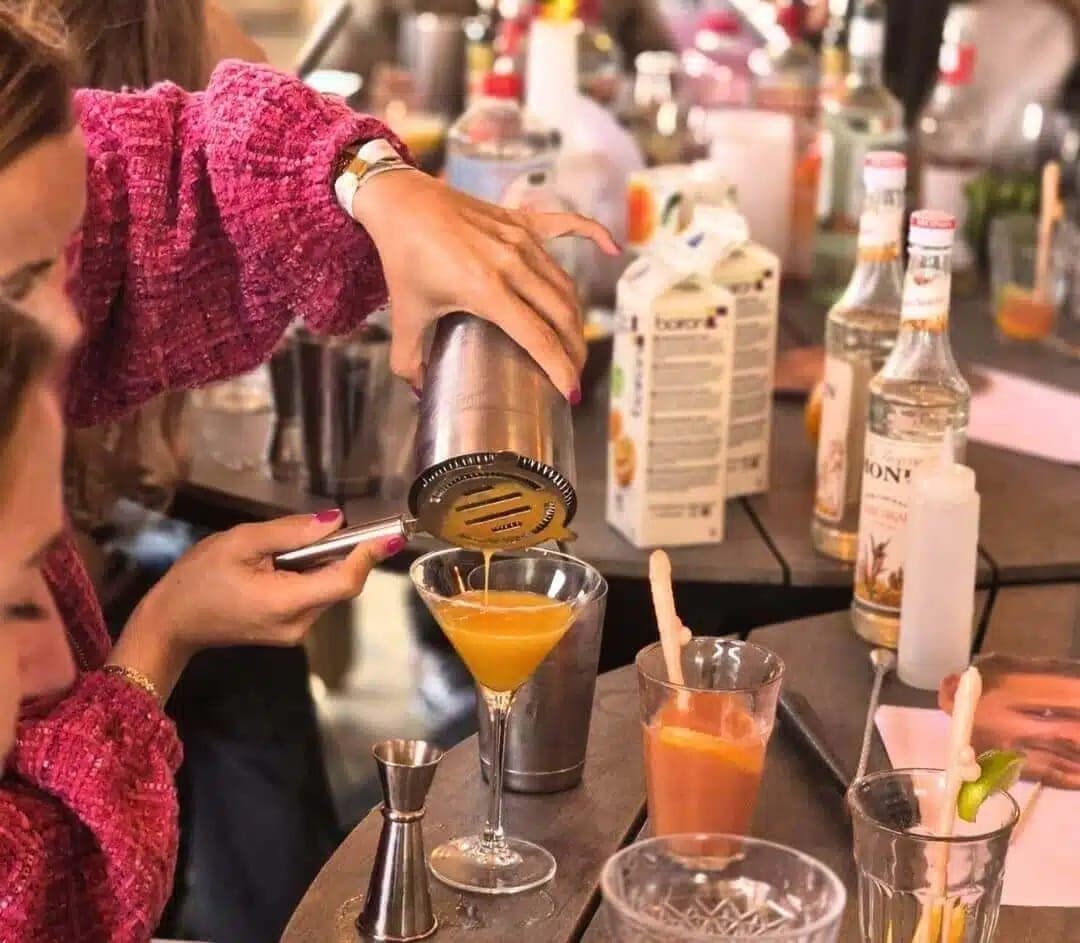 Deelnemer schenkt een zelfgemaakte cocktail uit de shaker tijdens de workshop