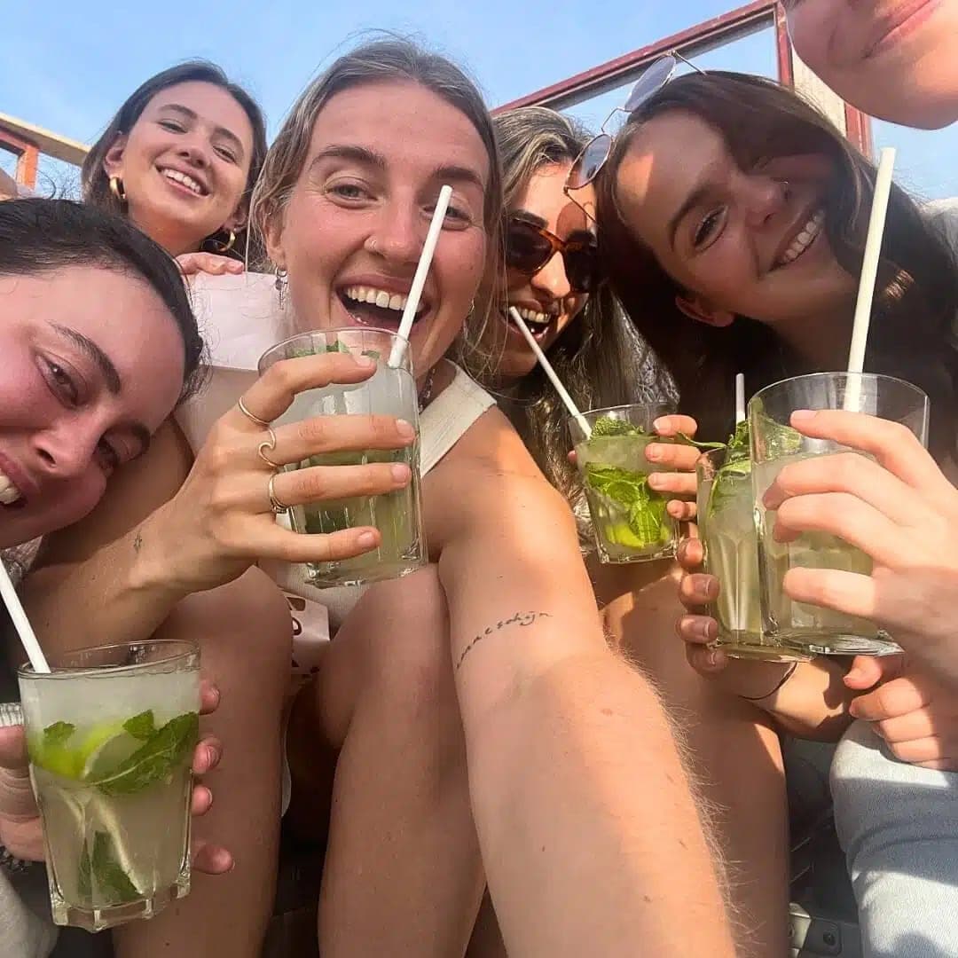 Vrienden toasten met zelfgemaakte mojito’s na de cocktail workshop